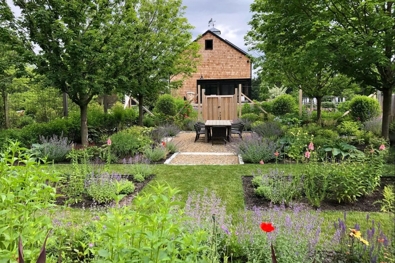 Carlisle, MA - A garden setting with native plantings surrounding a simple barn structure, creating a functional outdoor space that blends naturally with its surroundings.