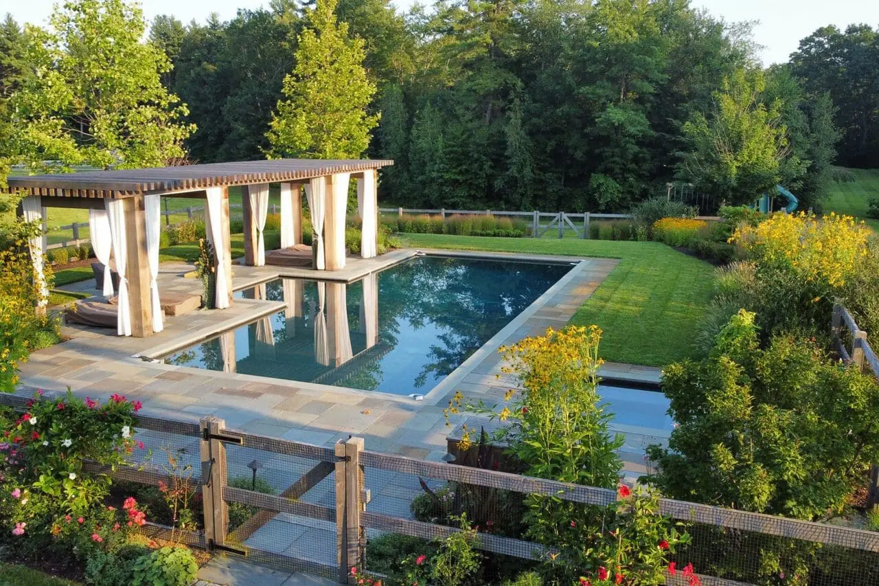 Carlisle, MA - A poolside landscape with layered plantings and natural materials, designed to create a relaxed, sustainable outdoor environment that blends seamlessly with the surroundings.