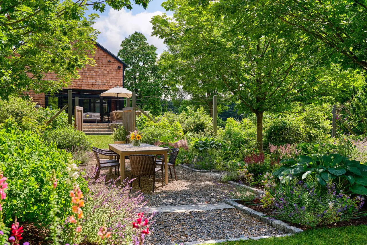 Carlisle, MA - A gravel dining terrace sits within flowering borders, creating an inviting space for outdoor meals tied to the surrounding gardens. Photo: Sean Litchfield