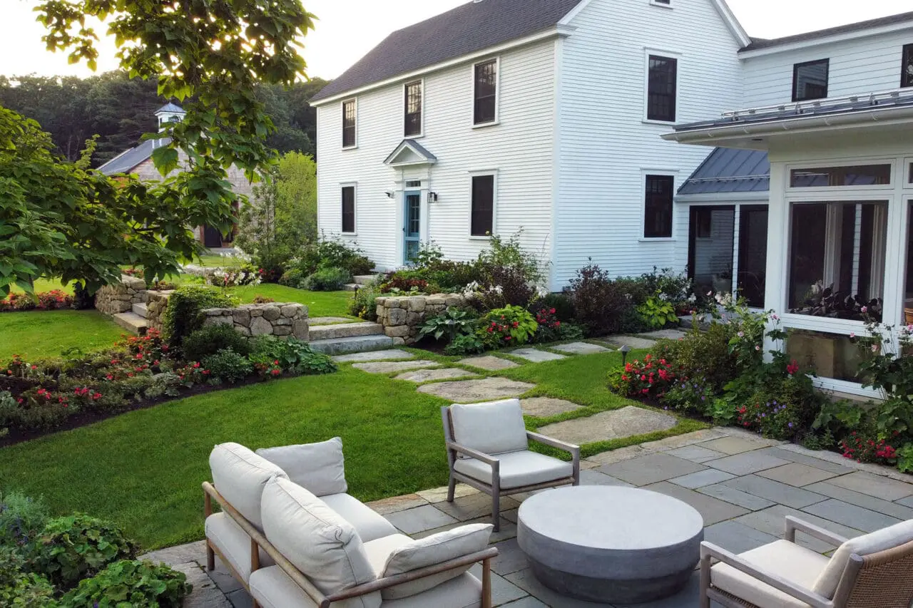Carlisle, MA - A stone terrace steps down to an open lawn, preserving long views while reinforcing the farmhouse’s historic character through restrained materials and balanced proportions.