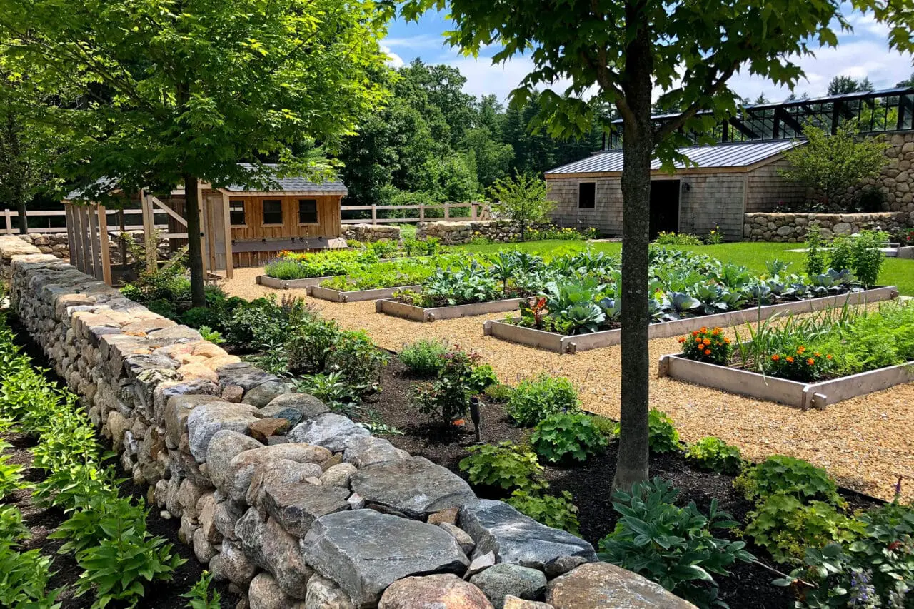 Carlisle, MA - Seasonal plantings fill raised beds bordered by stonework, showcasing a productive landscape designed for beauty, access, and crop rotation. Photo: Sean Litchfield