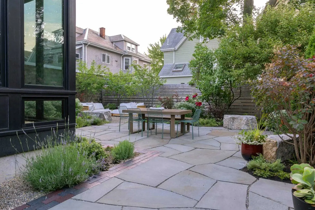 Cambridge, MA - Irregular bluestone paving creates an organic foundation for outdoor dining, while layered planting establishes depth and enclosure within the compact footprint. Photo credit: Dan Kaplan