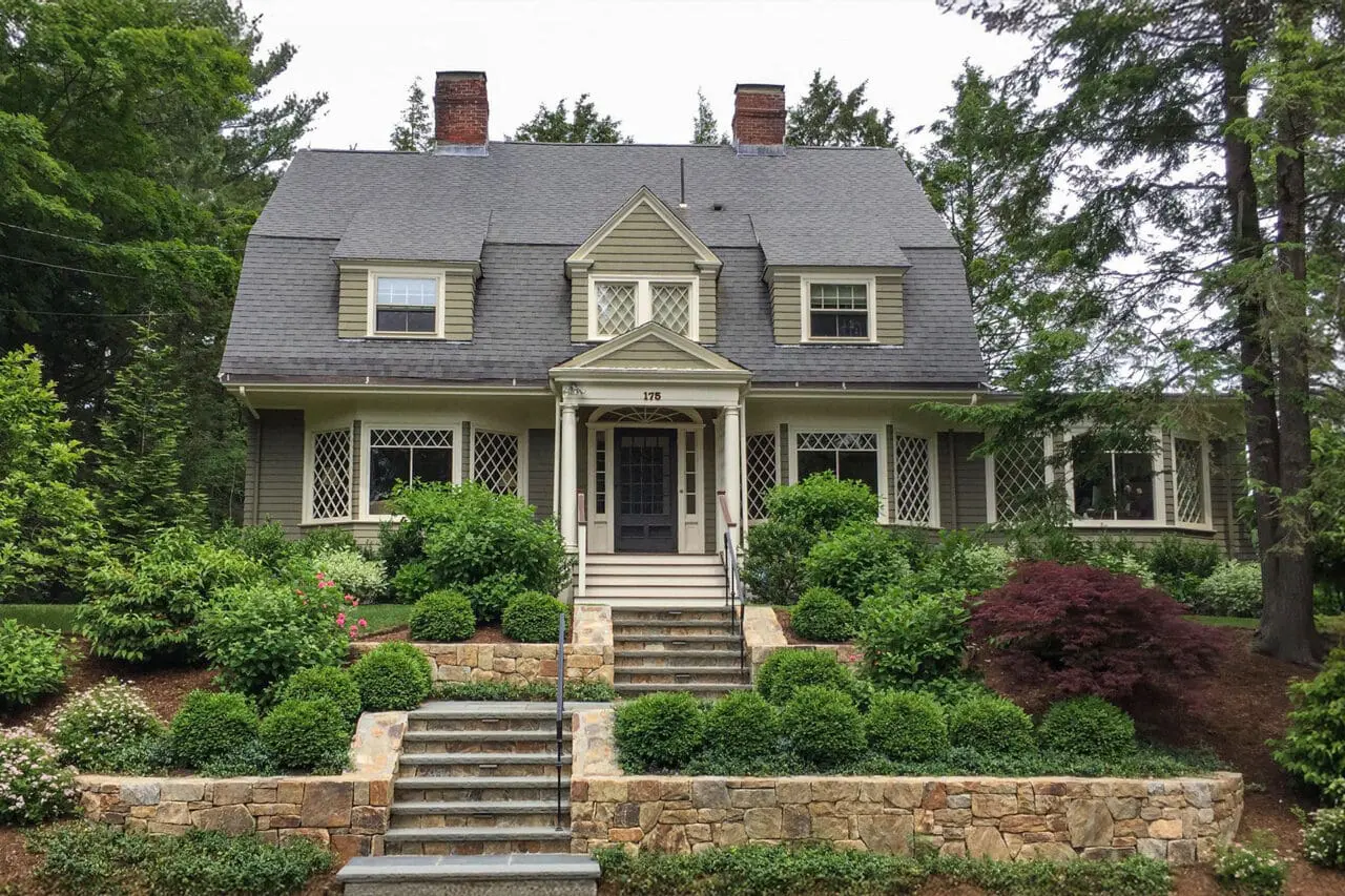 Newton, MA - After the redesign, a new front terrace creates a more inviting transition between the home and landscape, with defined gathering space, layered plantings, and stronger connections to the entry and lawn.