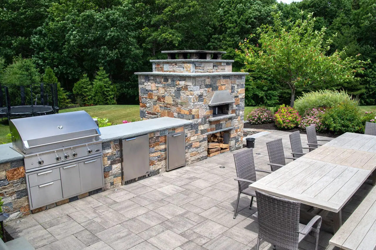 Designer-built gas grill integrated into stonework, creating a refined outdoor kitchen and dining experience.