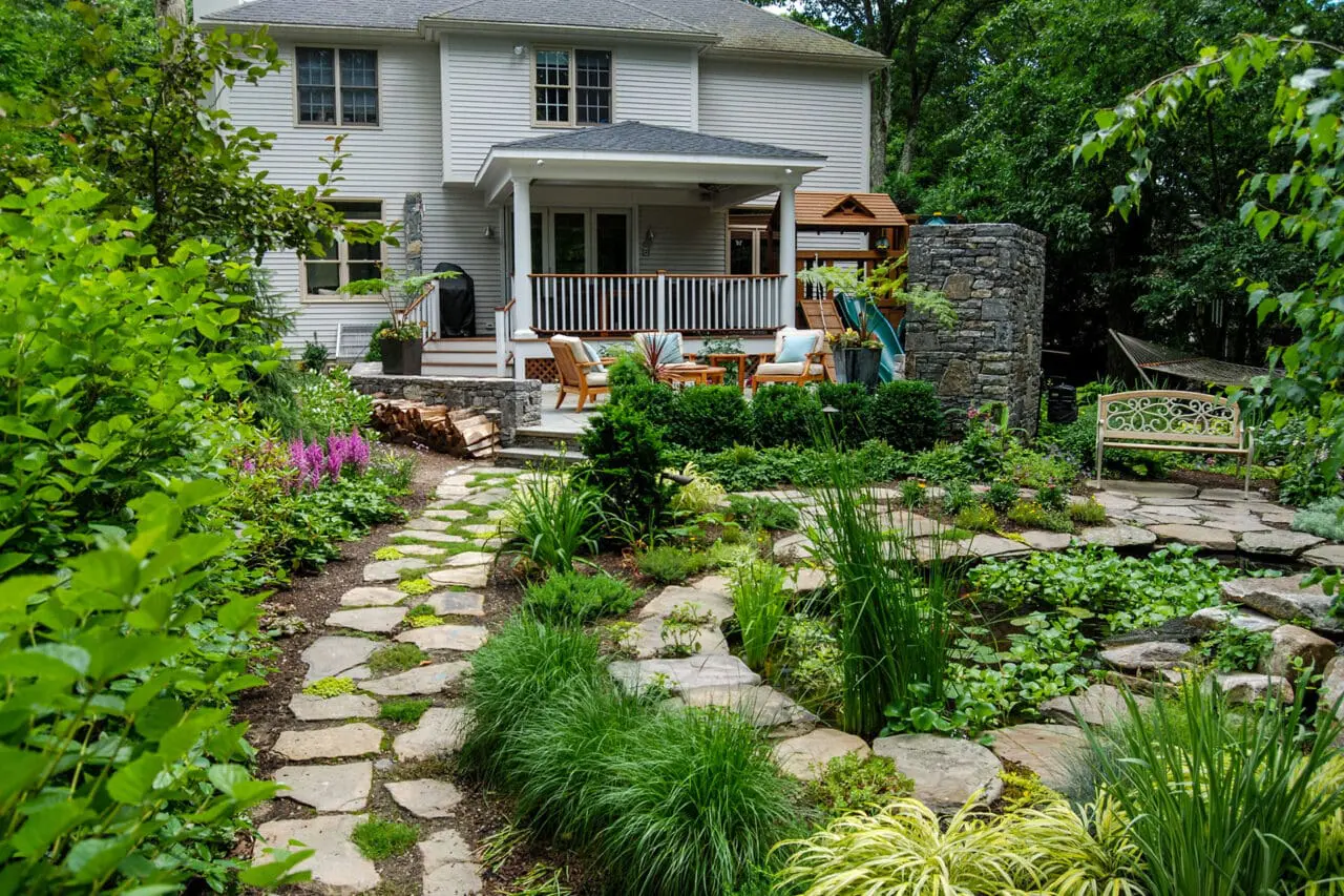 Flagstone garden path weaves through lush planting, encouraging exploration while maintaining a soft, natural feel.