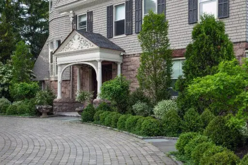 Brookline, MA - Mixed foundation shrubs surround this historic entry, balancing evergreen mass with varied textures to complement architecture and create a welcoming approach.