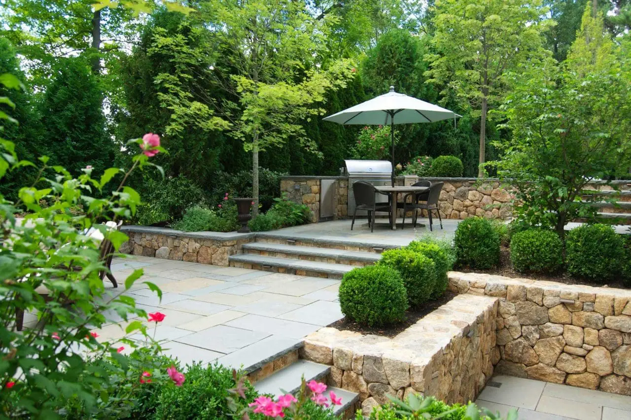 Wellesley, MA - tiered stone patio with grill and boxwoods, landscape design