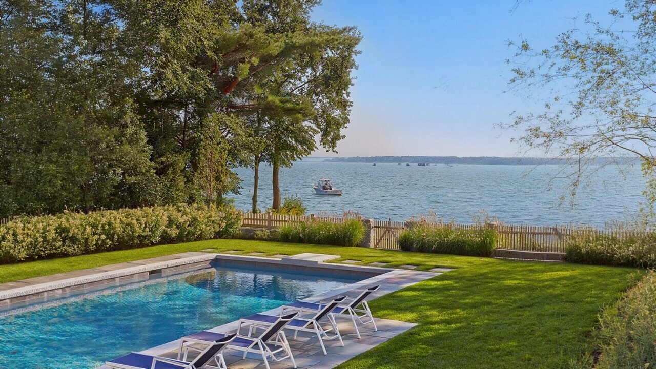 This Duxbury landscape pairs a stone pool terrace with layered coastal planting while preserving open water views.