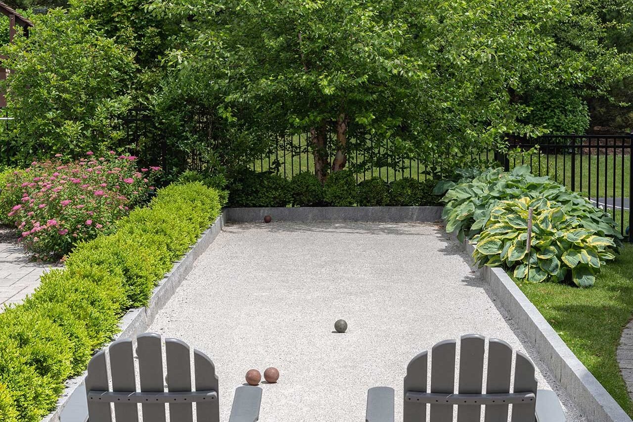 Formal boxwood hedge in Wayland, Massachusetts, creating a low evergreen privacy screen along a residential garden.
