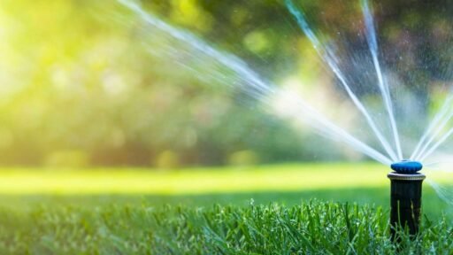Residential lawn irrigation system running across a landscaped property, illustrating sprinkler coverage and the need for timely irrigation system upgrades.