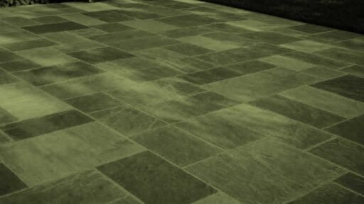 Belmont, MA - This dry-laid bluestone patio shows how frost heave, poor drainage, or an unstable base can cause individual stones to lift, sink, or rock after winter.