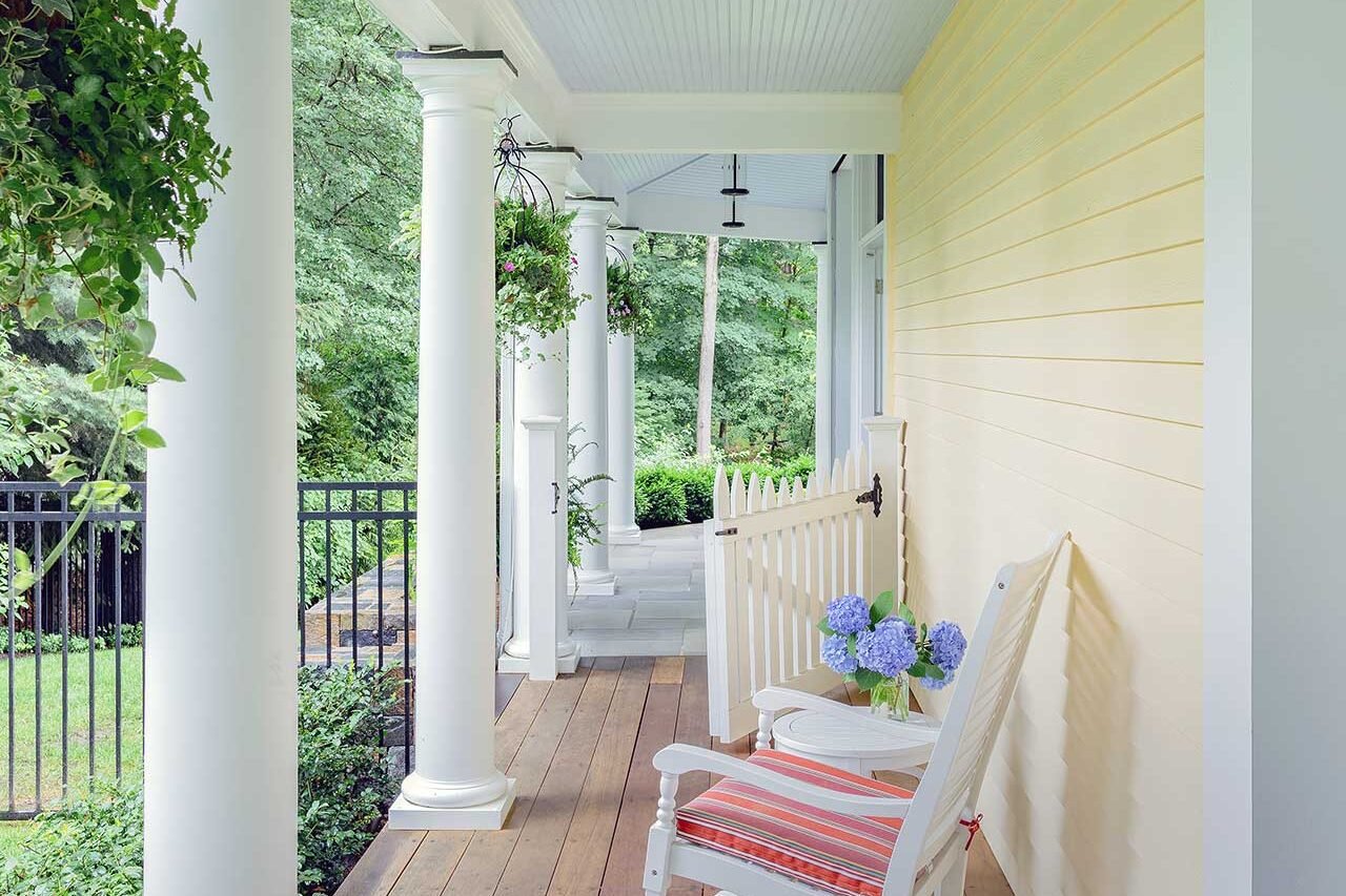 Wellesley, MA - A covered side porch adds a quieter, more intimate edge to the property, with warm decking and garden views that extend the outdoor living experience. photo credit: Michael J Lee