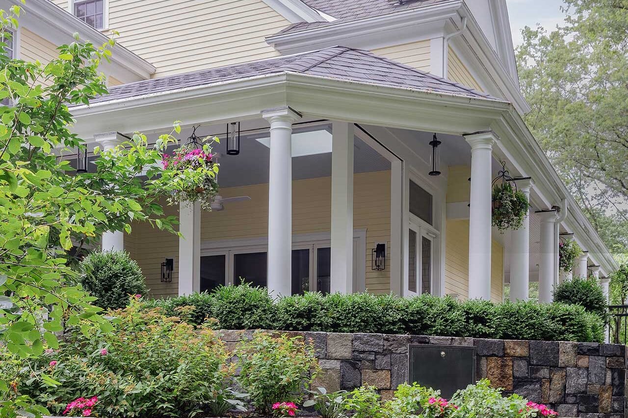Wellesley, MA - Terraced stone garden walls and layered foundation planting reinforce the home’s architecture while softening the transition into the landscape. photo credit: Michael J Lee