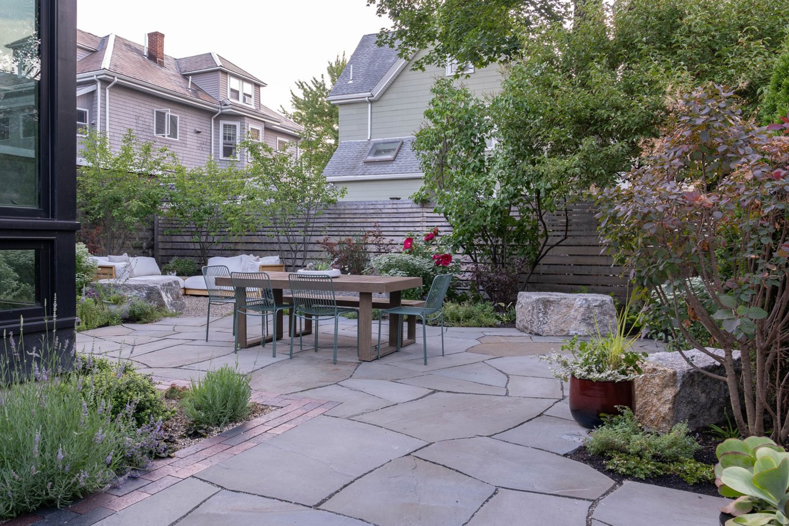 Somerville compact backyard with stone patio and dining area