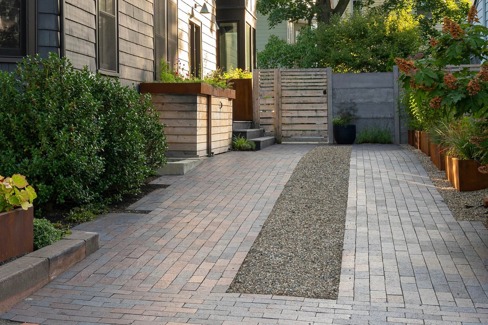 Cambridge driveway with pavers, gravel strip, and privacy gate
