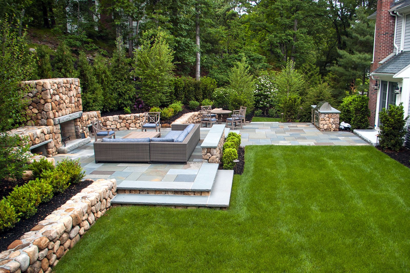 Wellesley backyard with terraced patio, fireplace, and outdoor kitchen