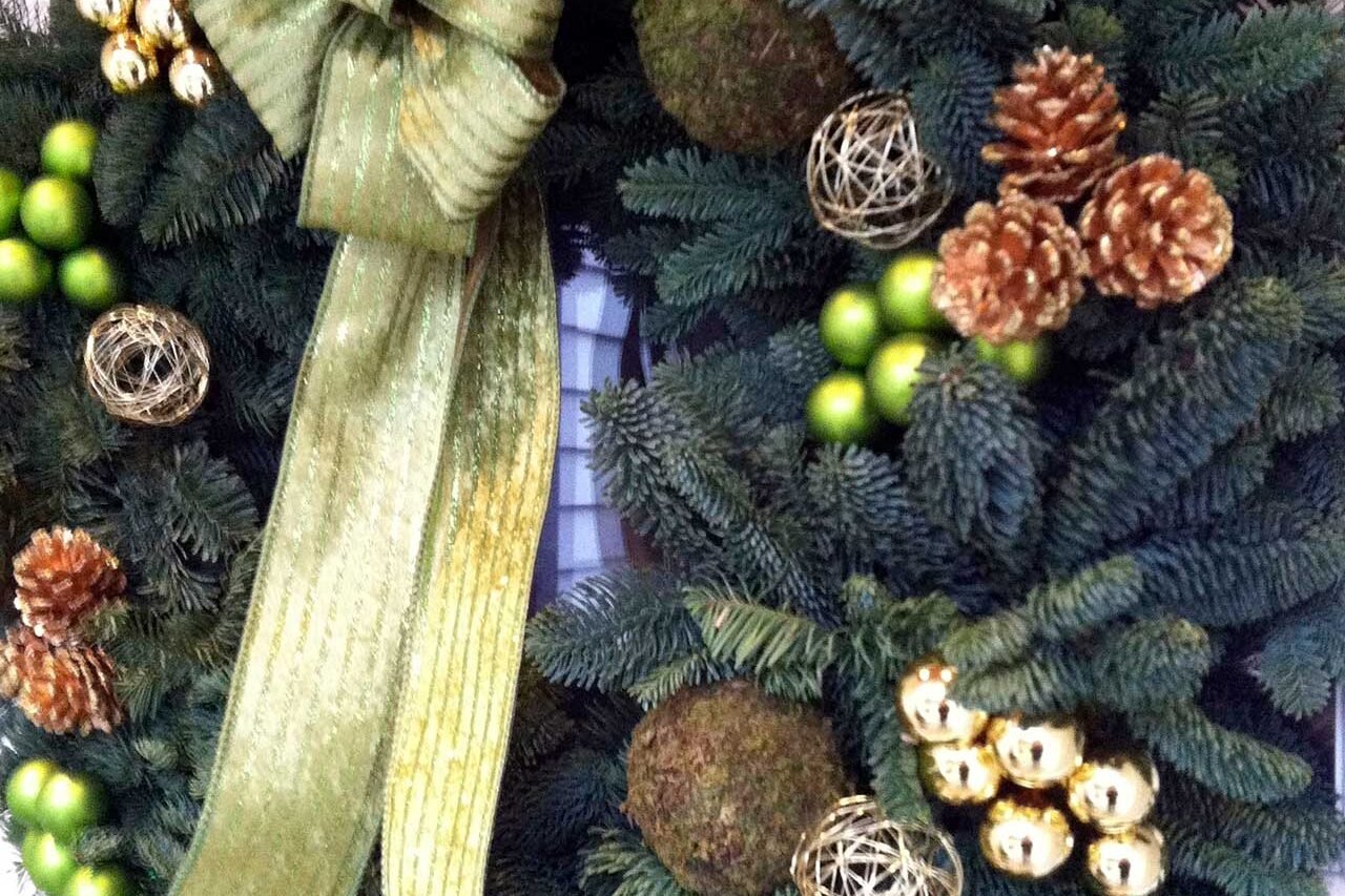 Green holiday wreath accented with subtle ornaments adds just enough detail to brighten the door while keeping a clean, classic look.