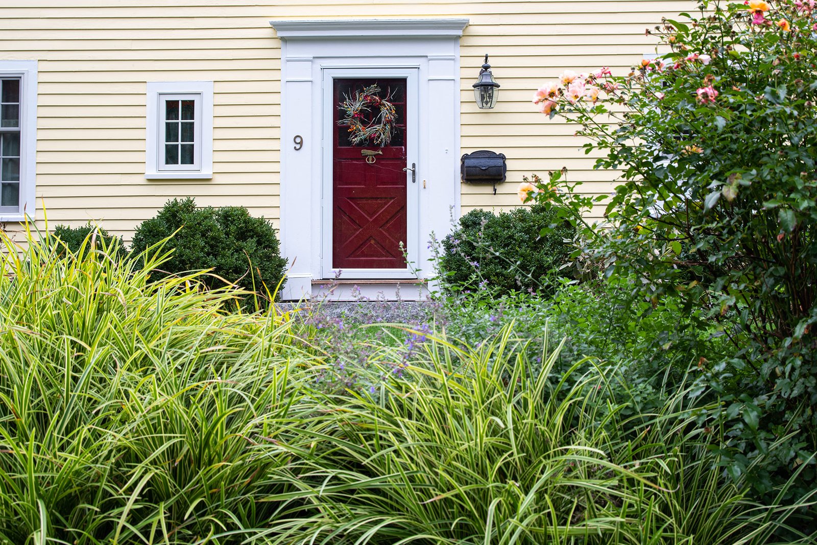 This wreath ties the entry garden to the home, using natural greens to add warmth and seasonal character with minimal effort.