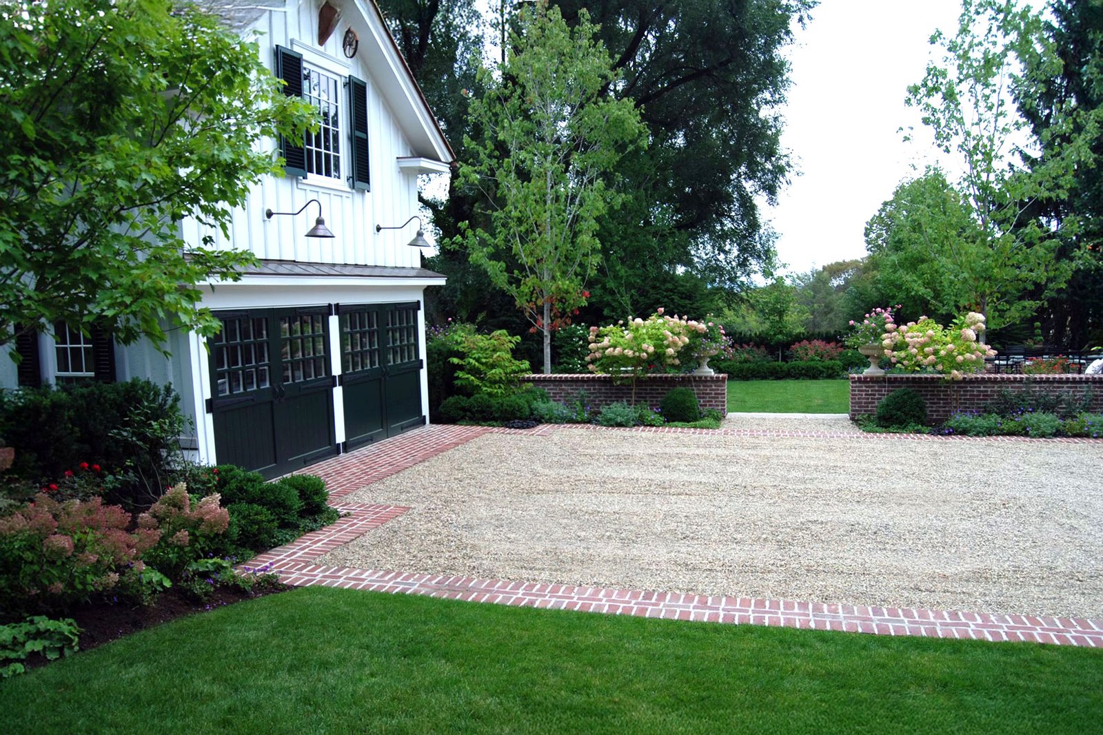 Belmont, MA - A gravel court driveway with brick borders forms a classic estate forecourt, offering generous turning space while reinforcing traditional materials and symmetry.