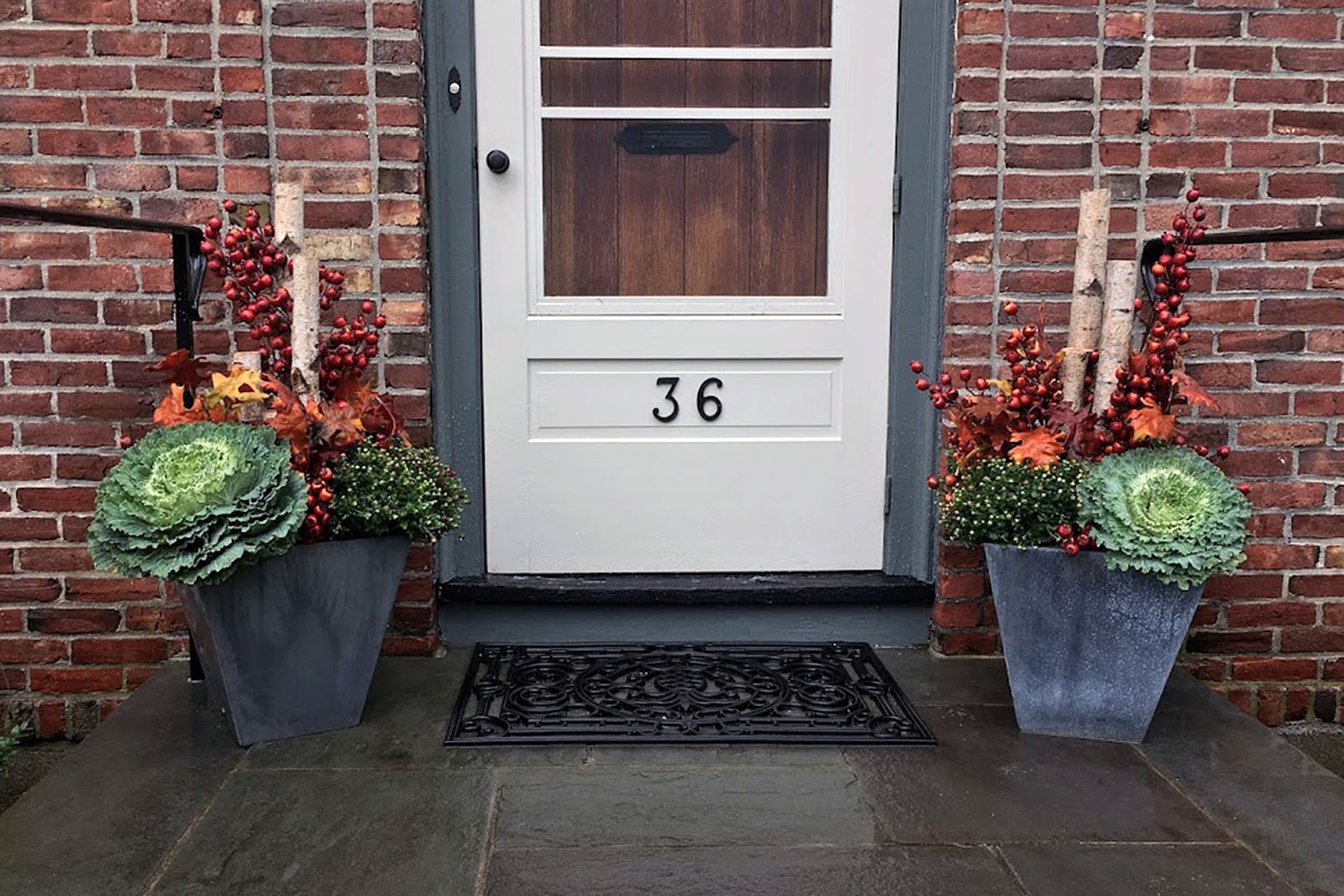Wellesley, MA entry planters featuring ornamental cabbage, red berries, and birch branches deliver bold symmetry and customizable autumn style.