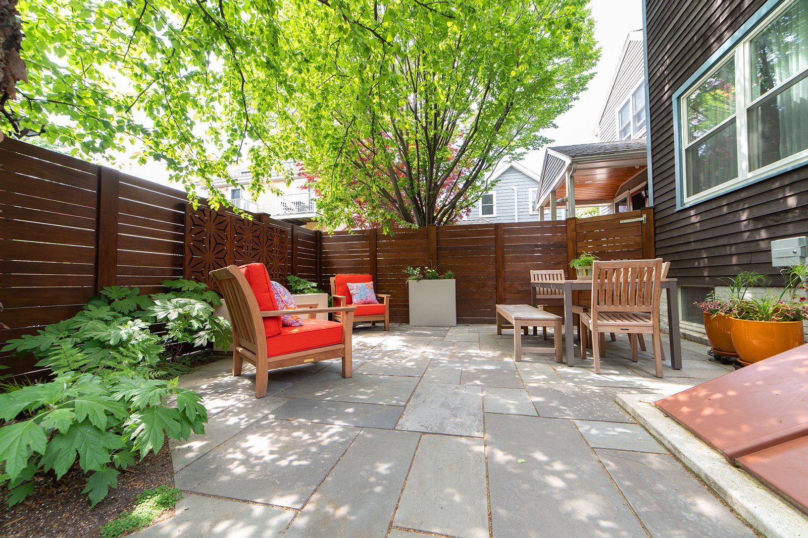 A modern wood privacy fence shields this Cambridge patio, transforming a compact urban space into a quiet outdoor retreat.