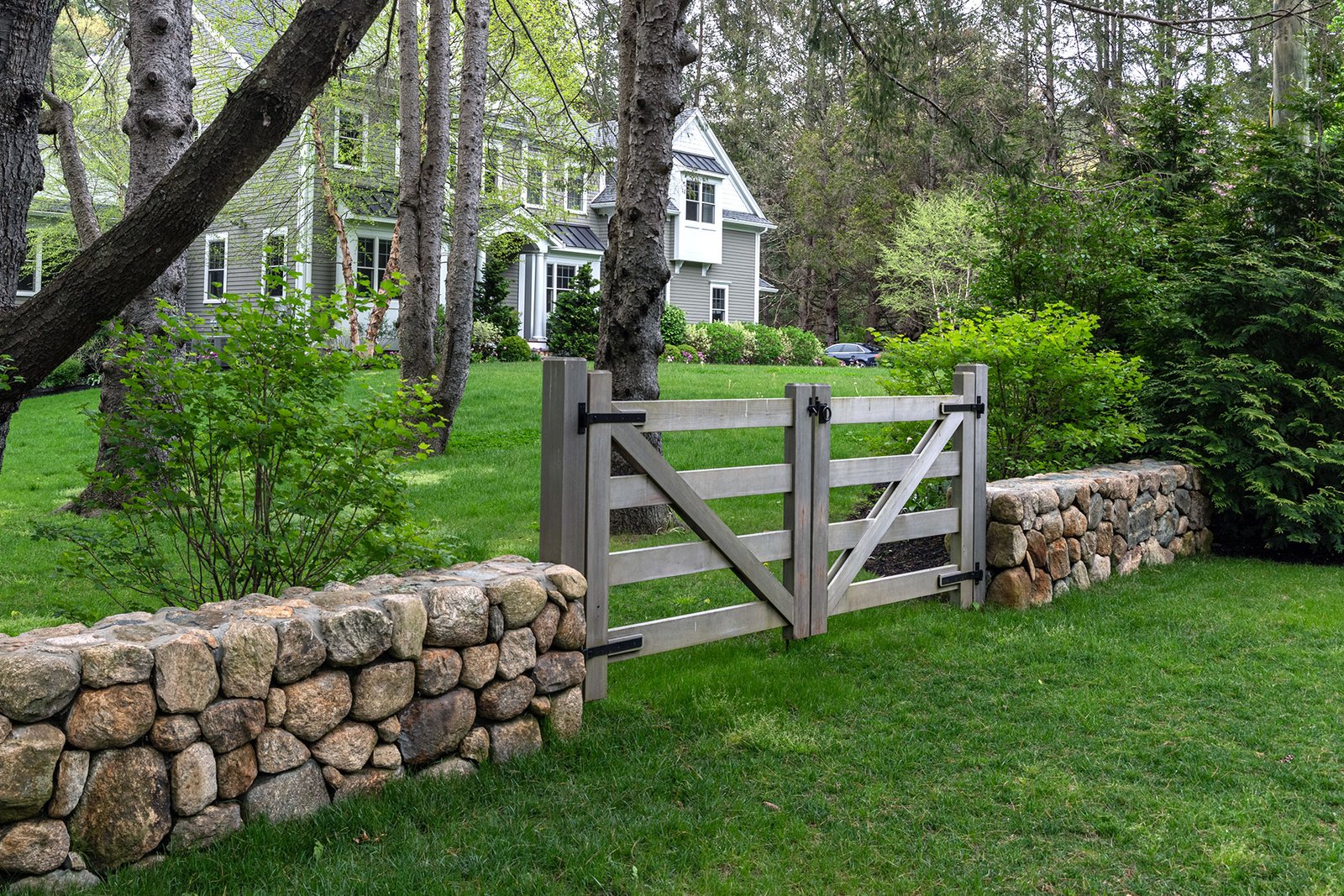 Ranch-style wood fencing defines pool and garden areas, balancing safety requirements with an open, family-friendly appearance.