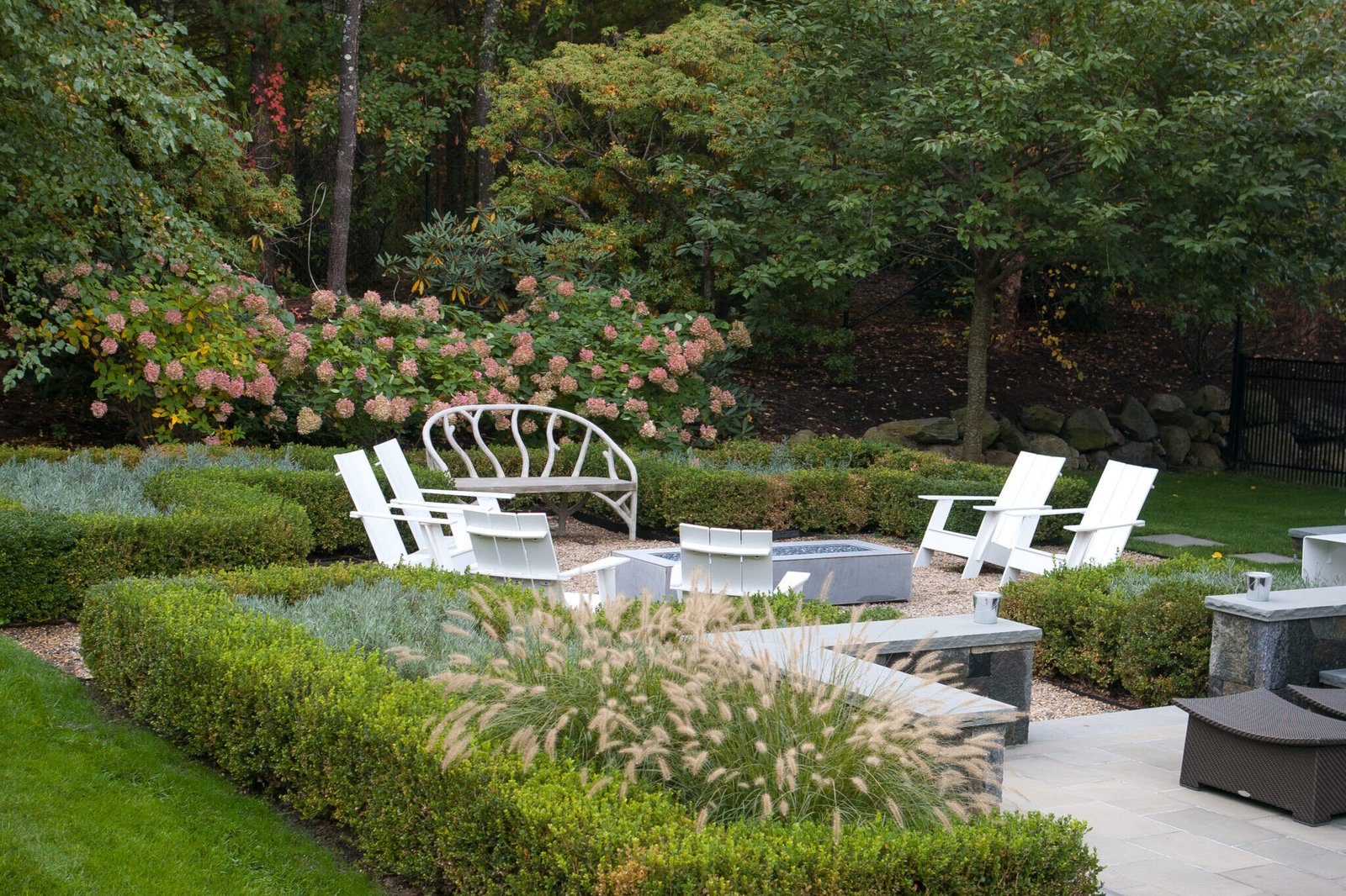 Fountain grass softens a modern stone terrace in Weston, adding motion, contrast, and a refined transition between architecture and landscape.