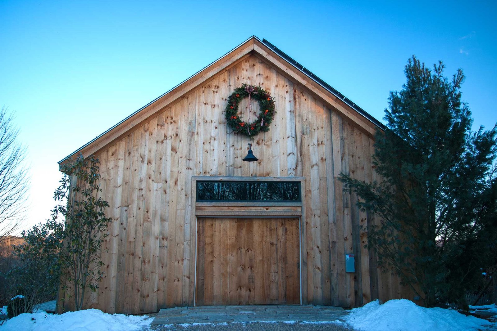Wayland, MA - Set against rustic wood siding, this evergreen wreath adds a simple festive accent that complements the barn’s natural character.