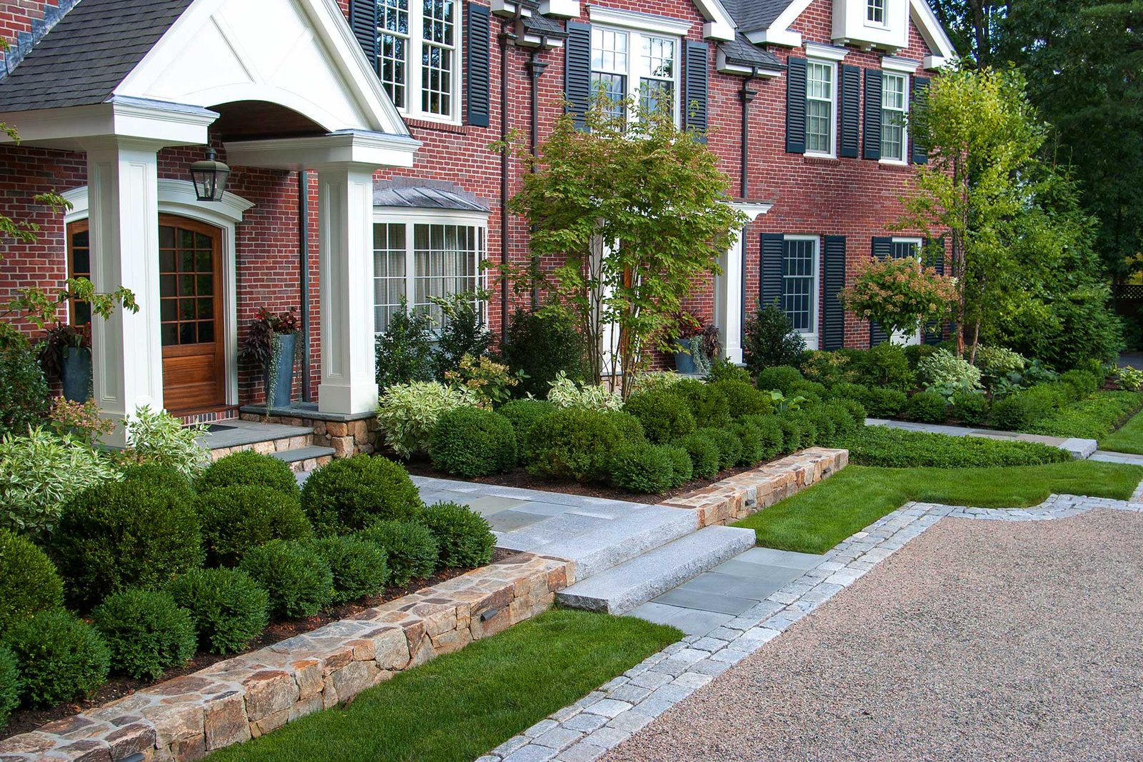 Wellesley Hills renovated front entry with layered planting and stone edging