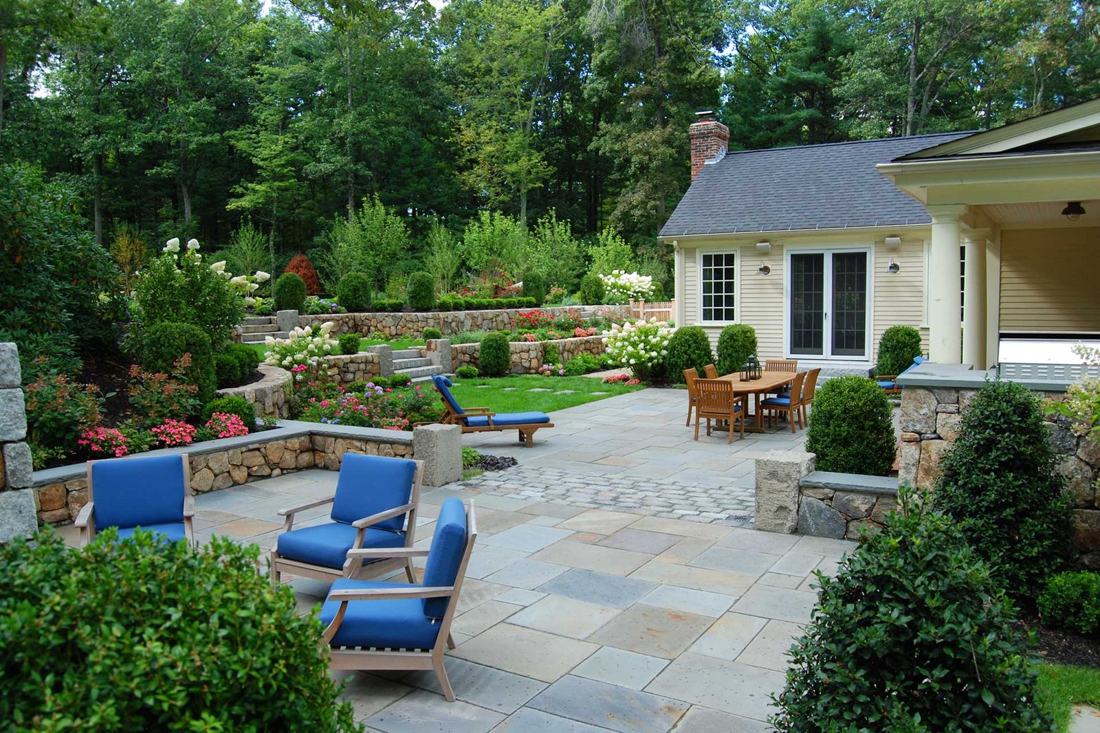 Dover backyard with stone walls, patio, and terraced planting