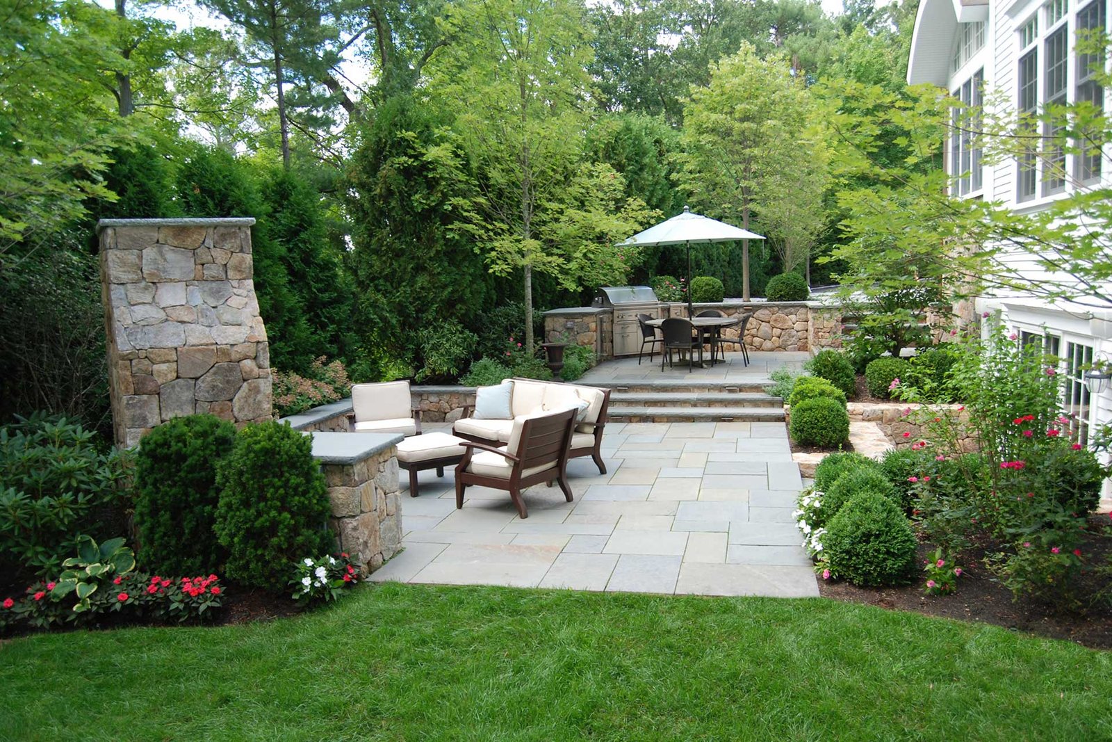 Multi-level outdoor rooms with stone patio, dining area, and seating