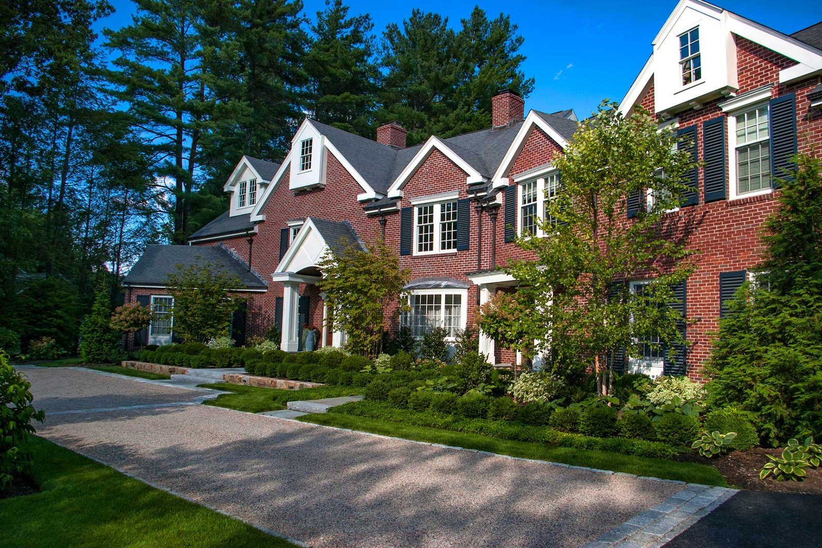Wellesley Hills front yard with layered planting and gravel drive
