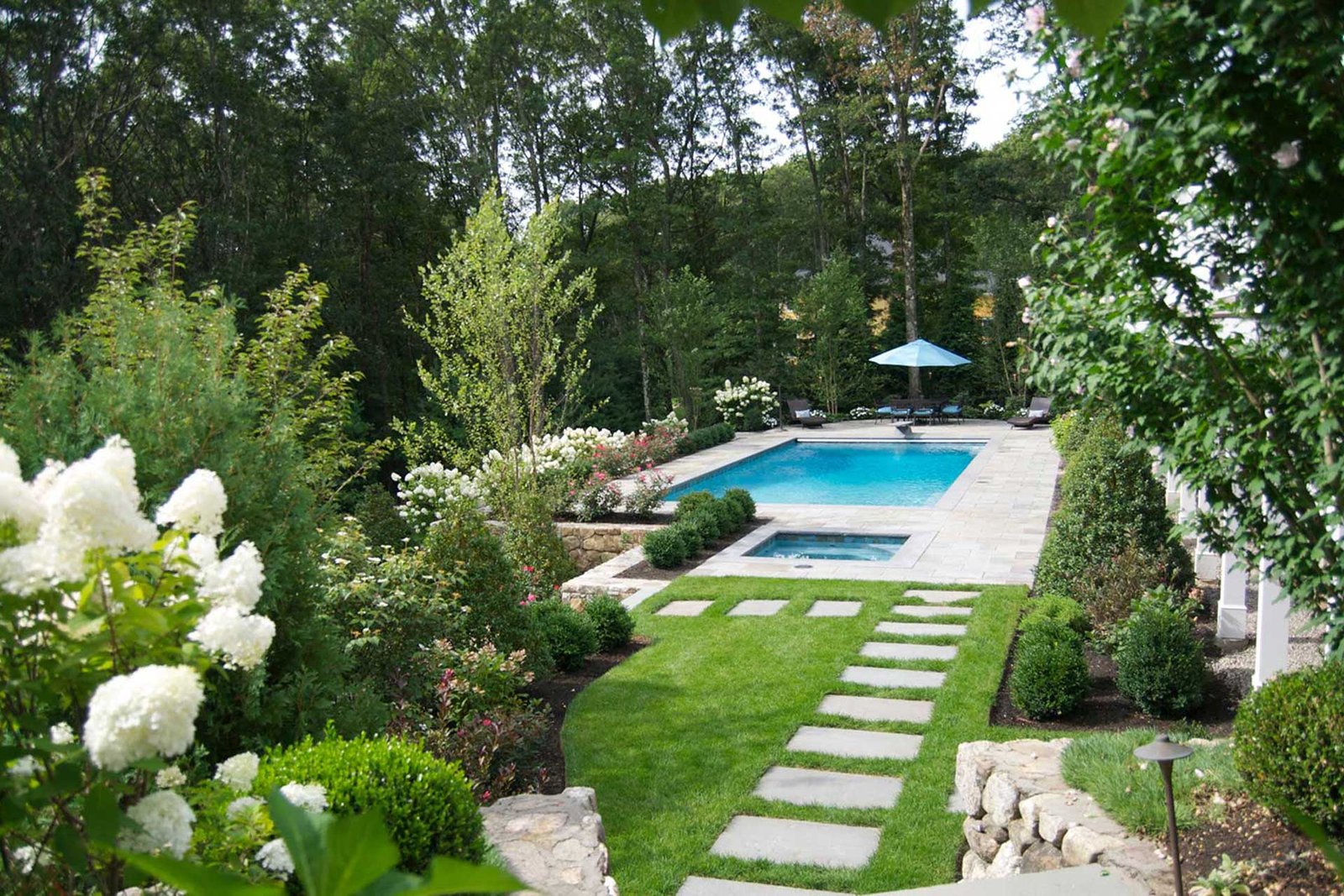 Weston hillside pool with lawn path and layered planting