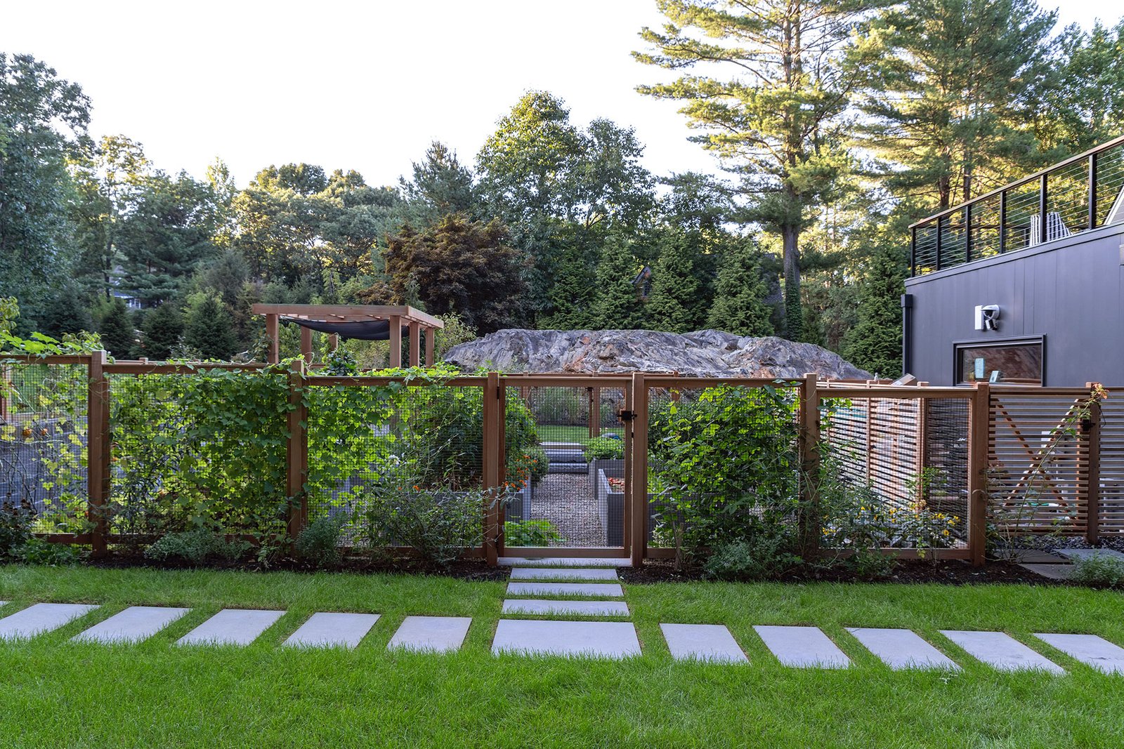 Modern raised beds paired with a pergola provide structure, partial shade, and extended usability during summer months.
