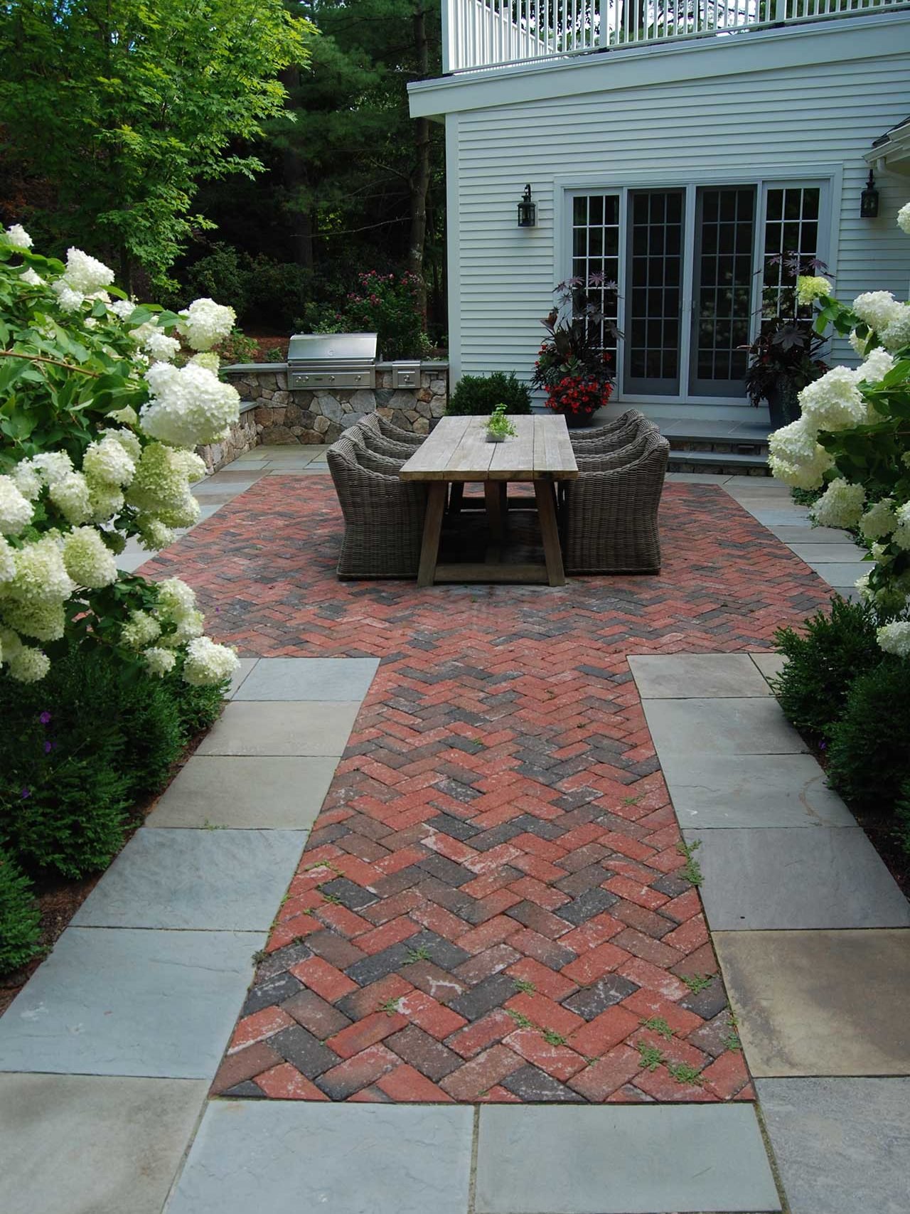 Wellesley Hills, MA - Herringbone brick and bluestone patio set the stage for this outdoor dining area.