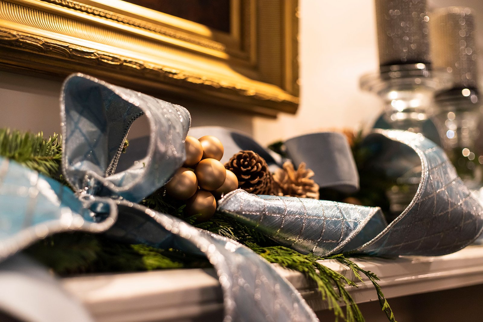 A natural evergreen garland with pinecones drapes across an interior mantel, adding simple texture and seasonal warmth to the room.