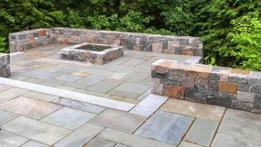 Wellesley, MA - Bluestone terraces and firepit supported by Corinthian granite seating walls provide outdoor gathering areas.